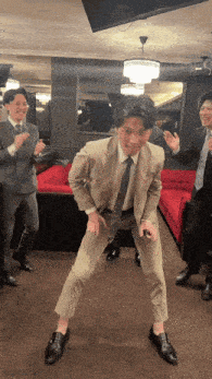 a man in a suit and tie is dancing with two other men