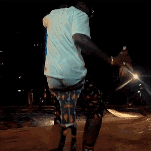 a man in a white shirt and shorts is dancing