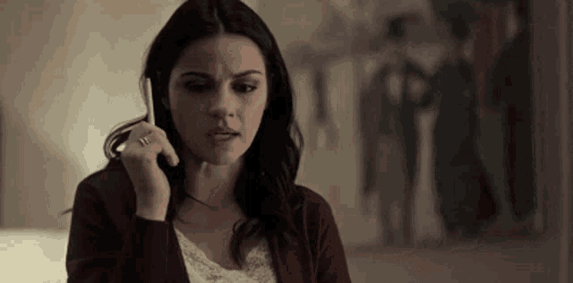 a woman is talking on a cell phone in front of a picture .