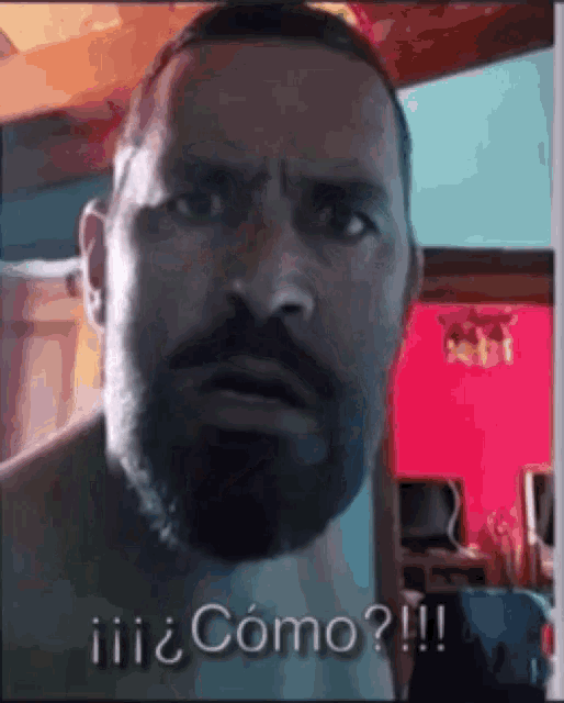 a man with a beard is making a funny face while talking to someone .