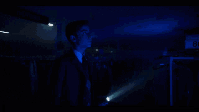 a man in a suit and tie says i 've missed you in a dark room