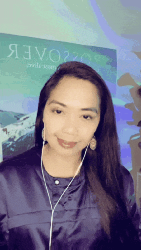 a woman wearing ear buds stands in front of a poster that says я3v020