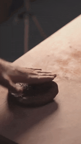 a close up of a person 's hands on a wooden table