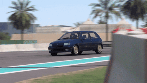 a blue car is driving on a race track with palm trees in the background