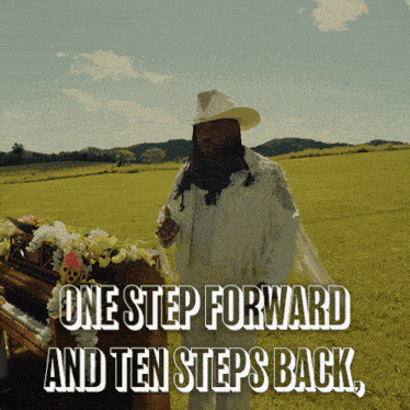 a man in a cowboy hat stands in a field next to a piano with the words one step forward and ten steps back