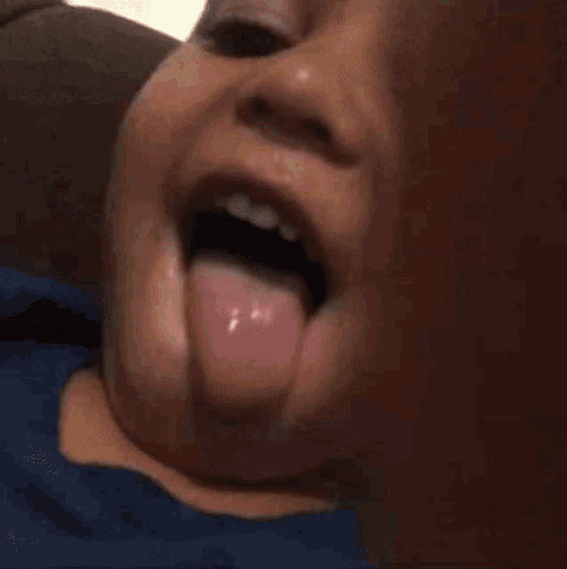 a close up of a child 's face sticking out his tongue