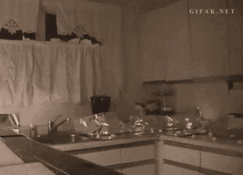 a gif from gifak.net shows a person flying through the air in a kitchen