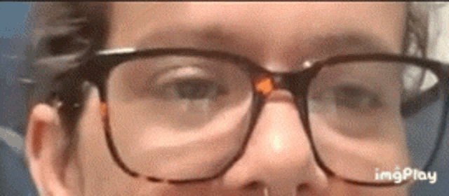 a close up of a person 's face with glasses on