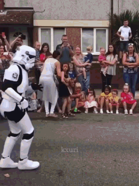 a storm trooper is dancing in front of a crowd of people with the hashtag kxuri