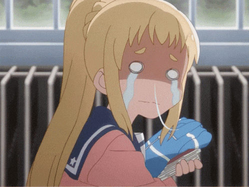 a girl in a sailor suit is crying while holding a blue glove