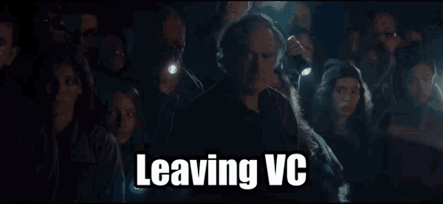 a group of people in a dark room with the words leaving vc written above them