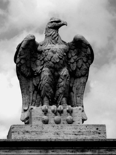 a black and white photo of a statue of an eagle with its wings outstretched