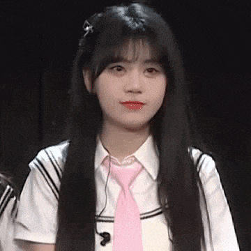 a girl with long black hair and a pink tie is wearing a school uniform .