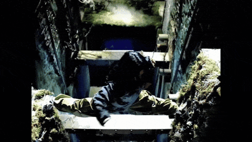 a person is sitting on top of a staircase in a dark room .