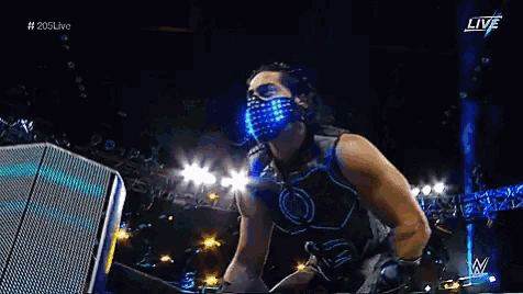 a wrestler in a futuristic costume is standing in front of a podium .