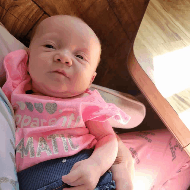 a baby wearing a pink shirt that says ' i love parents ' on it