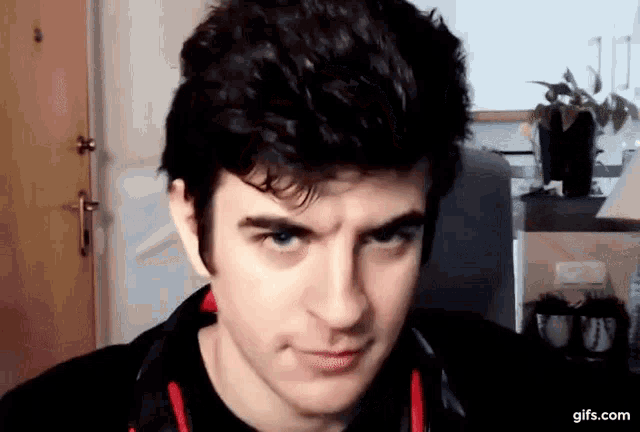 a man is making a funny face in front of a camera .