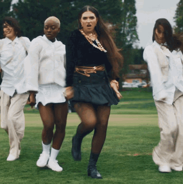 a woman in a black skirt is surrounded by other women