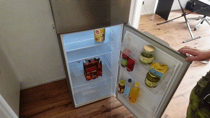 a person opens a refrigerator with a bag of tortilla chips in it