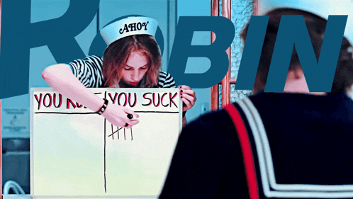 a woman wearing an ahoy hat is holding a sign that says you suck