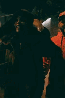 a woman with a very large breast is standing in a dark street
