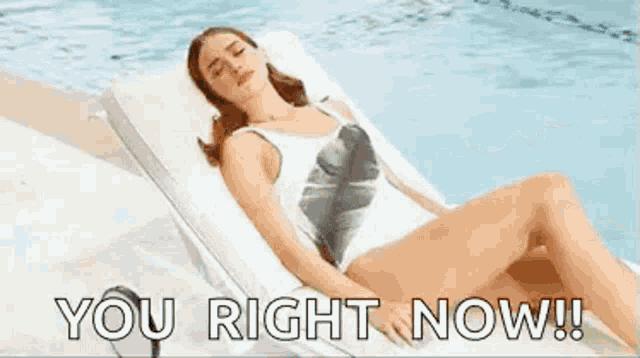a woman in a bathing suit is laying on a lounge chair next to a pool .