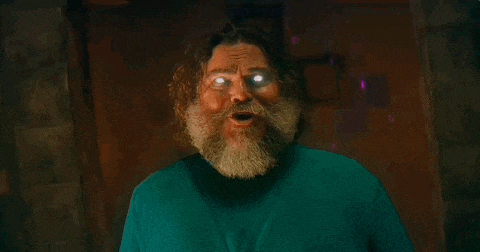 a man with a beard has glowing eyes and a green sweater