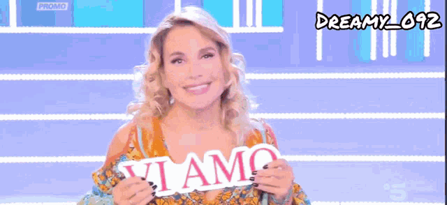 a woman is smiling in front of a blue background that says dreamy_012