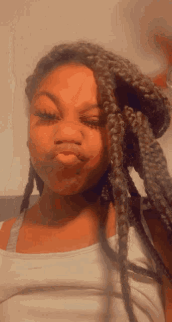 a woman with dreadlocks is making a funny face .