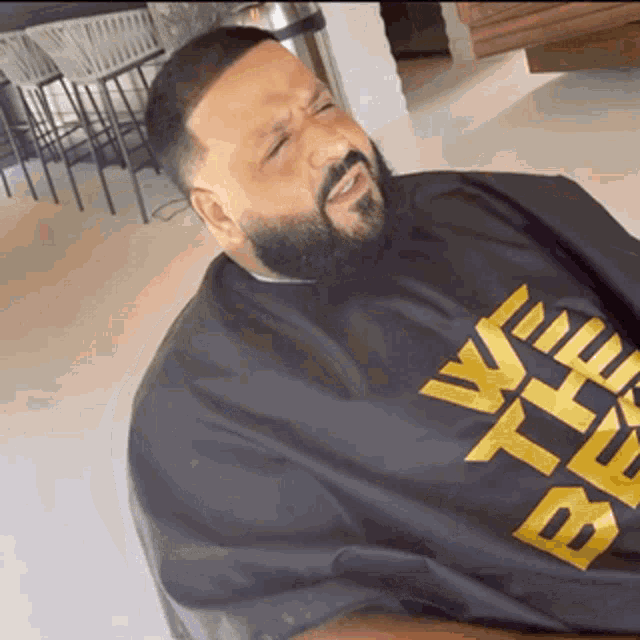 a man with a beard is wearing a black cape and a t-shirt with the word beef on it .