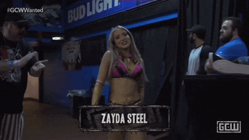 a woman named zayda steel stands in front of a crowd