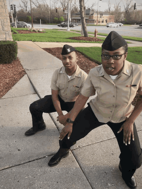 a man and a woman squatting on a sidewalk