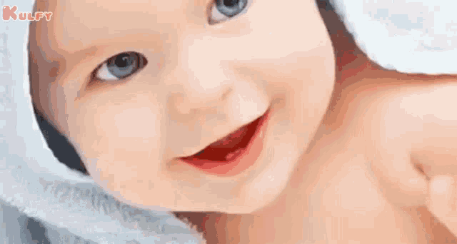 a baby is smiling and wrapped in a towel with the words `` good morning '' written below it .