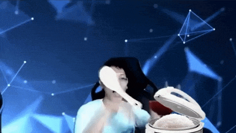 a woman is holding a spoon in front of a rice cooker .