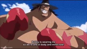 a man wearing boxing gloves is talking to another man in a hat .