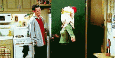 a man and a woman are standing in a kitchen next to a refrigerator .
