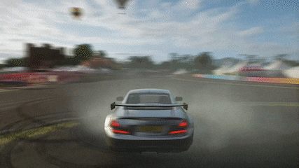 a car is driving down a road with a hot air balloon in the sky
