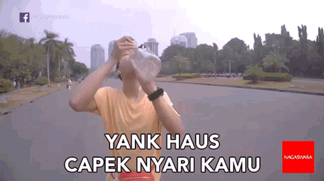 a man drinking water from a plastic bottle with yank haus capek nyari kamu written on the bottom