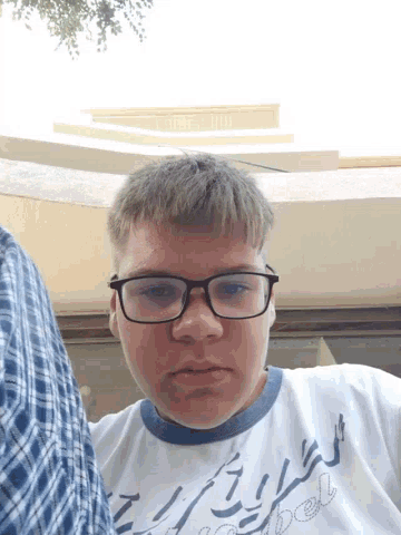 a young man wearing glasses and a shirt that says ' abercrombie ' on it