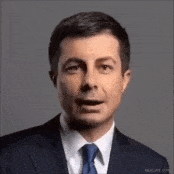 a man in a suit and tie is talking with his mouth open .