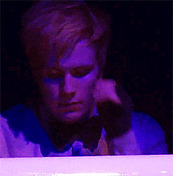 a man with purple paint on his face is holding his head