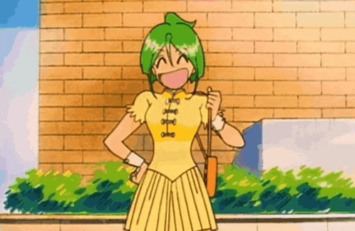 a girl with green hair is standing in front of a brick wall with her fist in the air