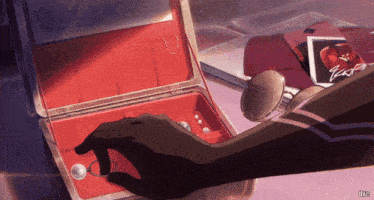 a person is holding a ring in a red box with the word ultra on the bottom left
