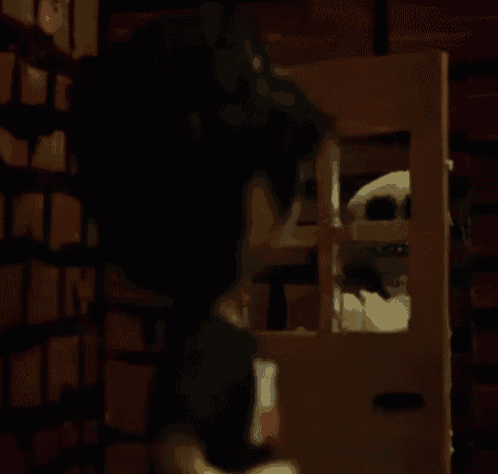 a woman is looking at a stuffed animal in a cage .