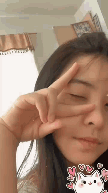 a woman making a peace sign with her hands