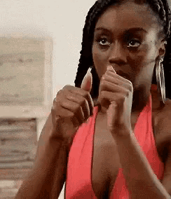 a woman in a red tank top is giving a thumbs up sign .