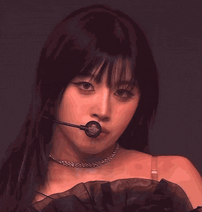 a close up of a woman with a microphone in her mouth .