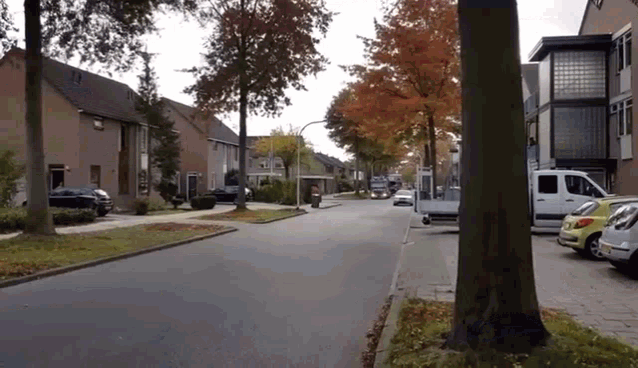 a white van is parked on the side of the road in a residential neighborhood