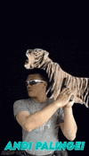 a man wearing sunglasses is holding a stuffed animal with a light coming out of its head .