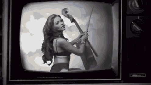 a black and white photo of a woman holding a cello on a television screen
